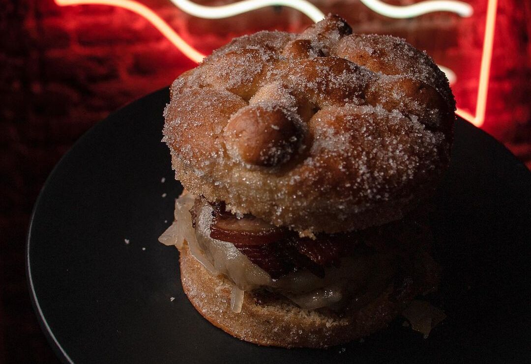 Crean el pan de muerto con tocino y lo convierten en hamburguesa
