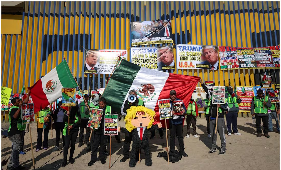 Migrantes y deportados castigan piñata de Donald Trump frente al muro fronterizo