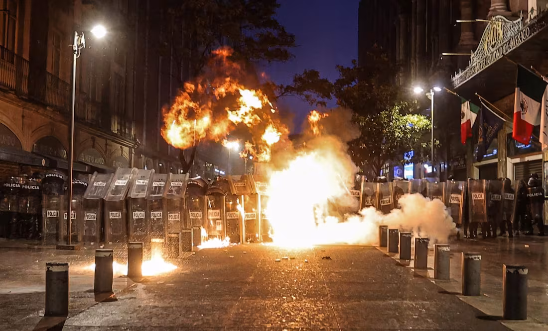 Arrojan petardos a policías en marcha por Ayotzinapa